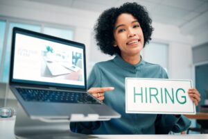 Woman, pointing and hiring sign, laptop and human resources with offer, recruitment and job opportu